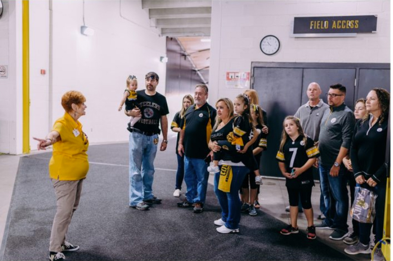 A stadium tour guide giving a tour to a group of fans